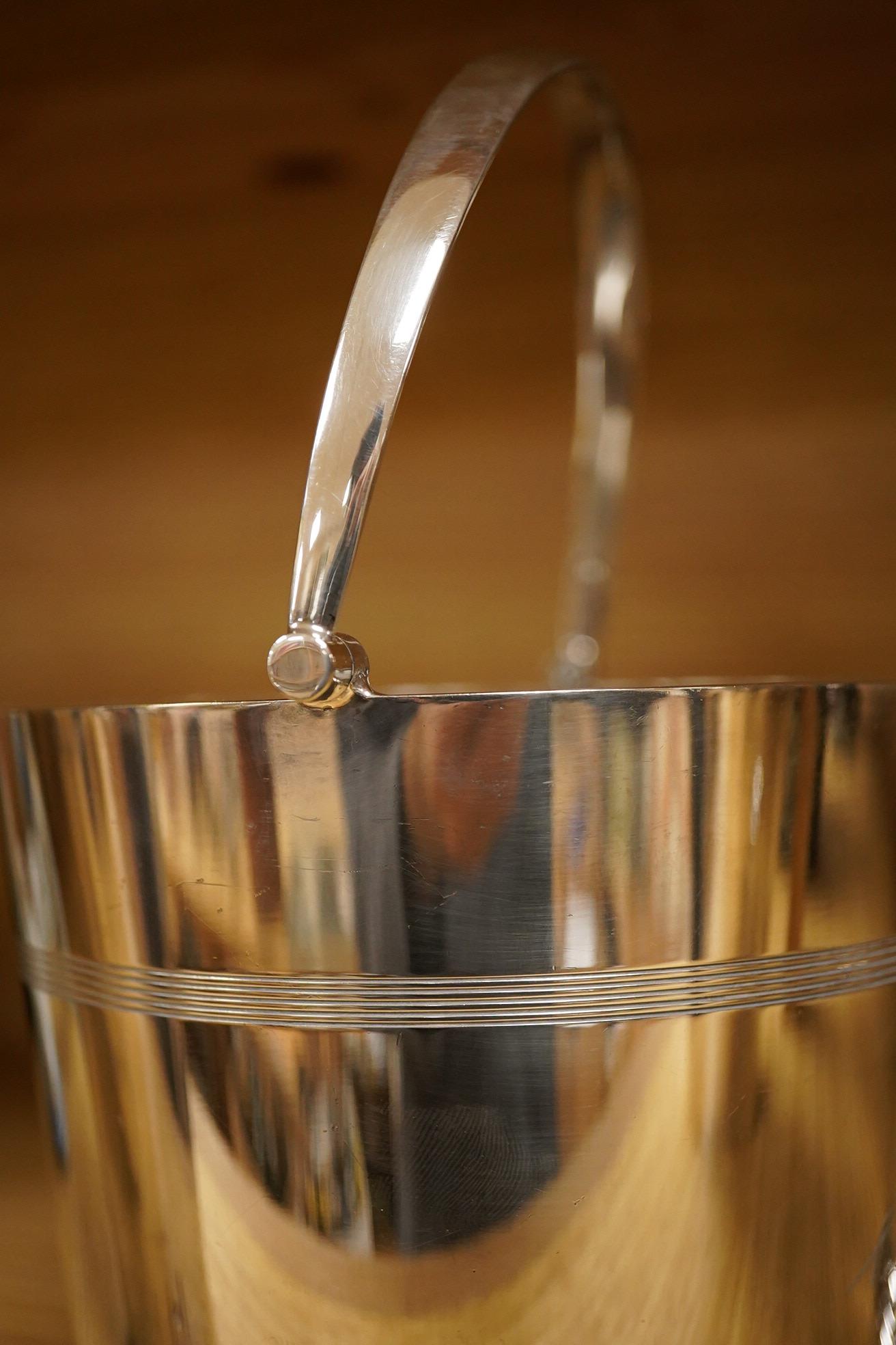 A mid 20th century silver plated patent cocktail shaker with recipes, two other cocktail shakers and an ice bucket, largest 28cm high